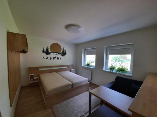 un salon avec un lit et un canapé dans l'établissement Vlčí nora, à Horní Maršov