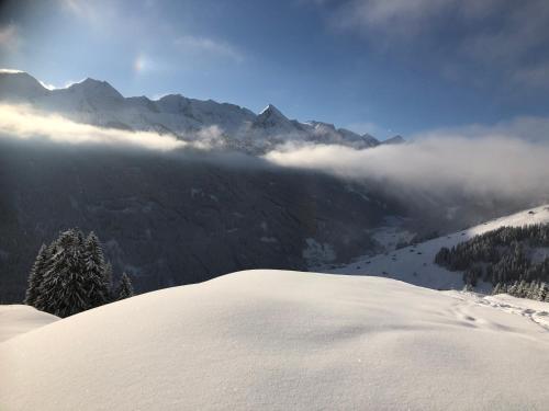 a snow covered mountain with clouds in the distance at Landhaus Zillertal in Ramsau im Zillertal