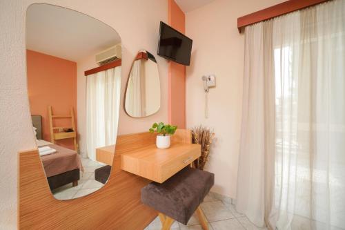 a room with a mirror and a table and a chair at Hotel Makrina in Skala Potamias