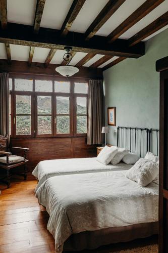a bedroom with a large bed and a large window at La Rectoral in Beloncio