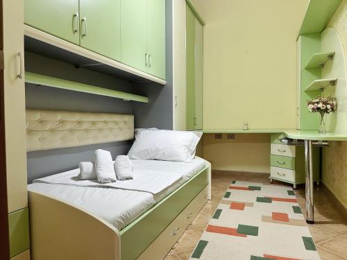 - une petite chambre avec un lit doté d'armoires vertes dans l'établissement SunKissed Centre Apartment, à Vlorë