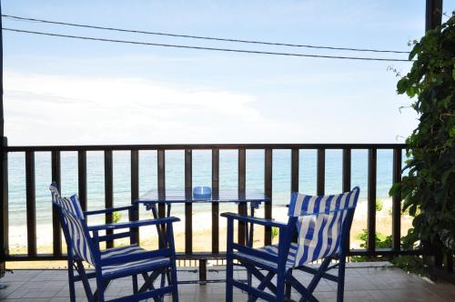 two chairs and a table on a balcony overlooking the ocean at Hotel Hagiati in Chorefto