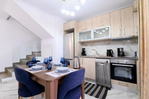 a kitchen with a wooden table and blue chairs at Sueño Suites in Parga