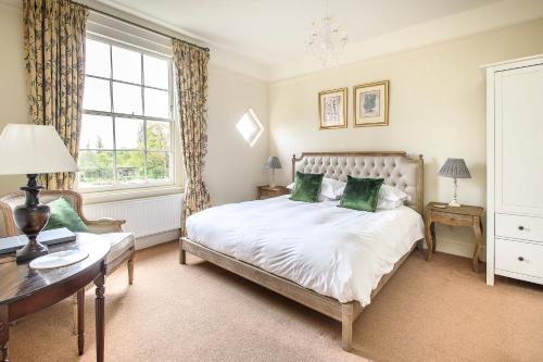 a bedroom with a bed and a desk and a window at Sissinghurst Castle Farmhouse in Sissinghurst