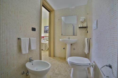 a bathroom with a white toilet and a sink at B&B La Casa di Attilio in Punta Prosciutto