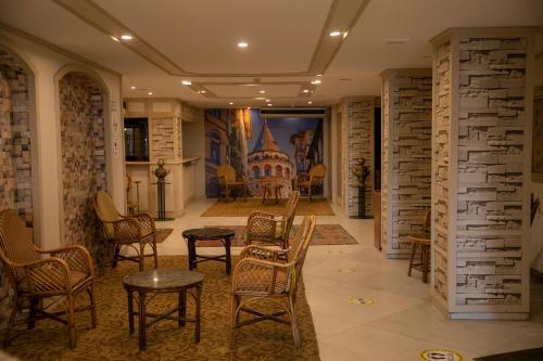 a room with chairs and tables and a painting on the wall at Hali Hotel in Istanbul