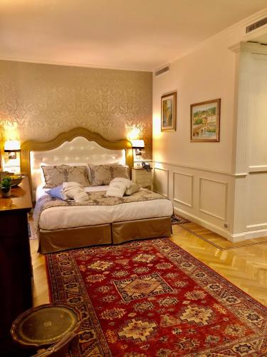 a bedroom with a large bed and a red rug at Relais Colle San Pietro in Verona