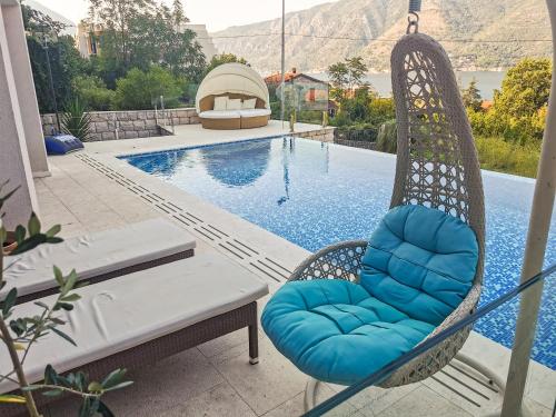 uma cadeira de baloiço ao lado de uma piscina em Villa Dea em Kotor