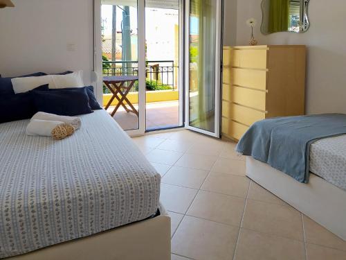 a bedroom with a bed and a door to a balcony at Seaside Villa Clio in Skála Nikíta