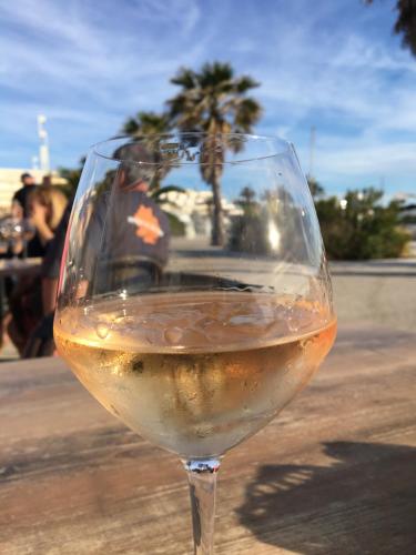 un verre de vin blanc assis sur une table dans l'établissement Blue Beach Studio, au Cap d'Agde
