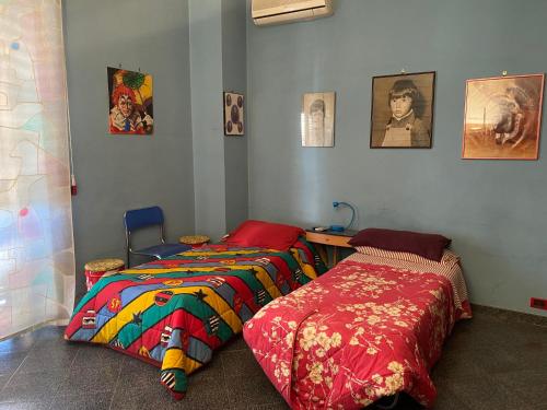 2 camas en una habitación con fotos en la pared en Dimora Nina, en Sannicandro di Bari