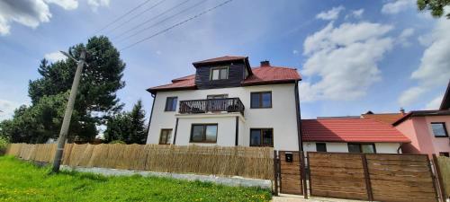 a white house with a fence in front of it at Privát Tatry Štrba in Štrba