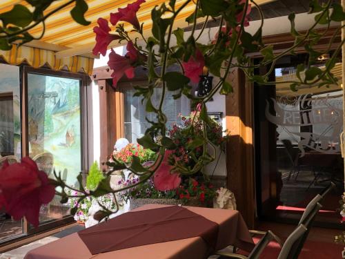 a table with flowers in a room with a window at Hotel Reitherhof in Reith bei Seefeld