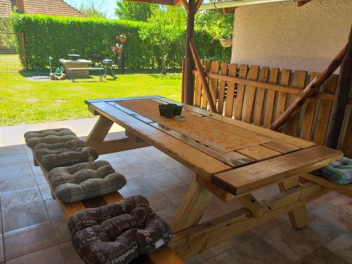 a wooden table and a bench and an umbrella at Otelló Nyaraló in Poroszló