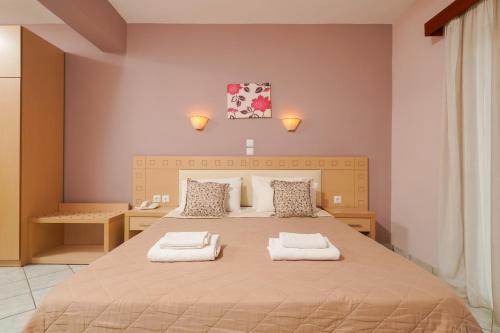 a bedroom with a large bed with two towels at Hotel Makrina in Skala Potamias