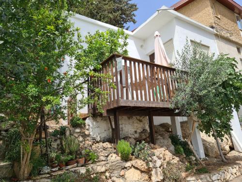 a house with a wooden balcony in the yard at The Artist's House Overlooking the Bay of Haifa in Haifa