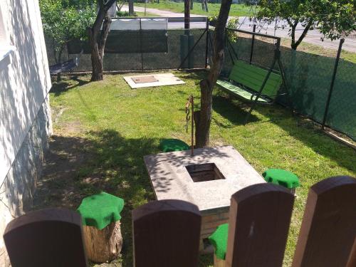 a backyard with a table and a tree and a fence at Otelló Nyaraló in Poroszló
