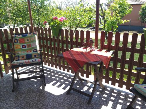 a table and a chair next to a fence at Otelló Nyaraló in Poroszló