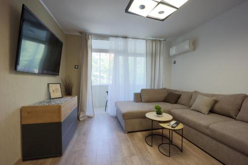sala de estar con sofá y TV de pantalla plana en Apartments Relax 3&4, en Varna
