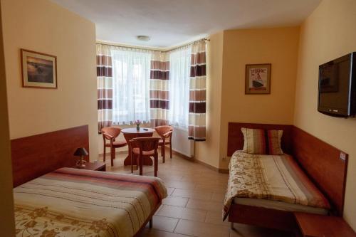 a hotel room with two beds and a table at Holiday-Darłówko in Darlowko