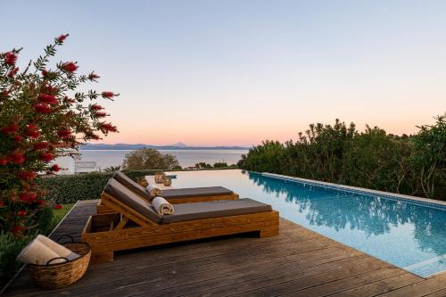 a swimming pool with a chaise lounger next to a swimming pool at Kappa Resort in Paliouri