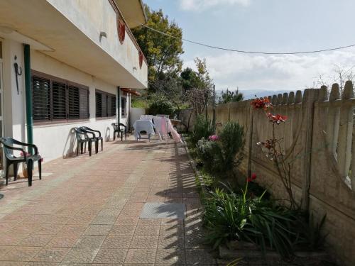 a patio of a house with chairs and a fence at in COLLINA di Reggio Calabria villetta in Orti