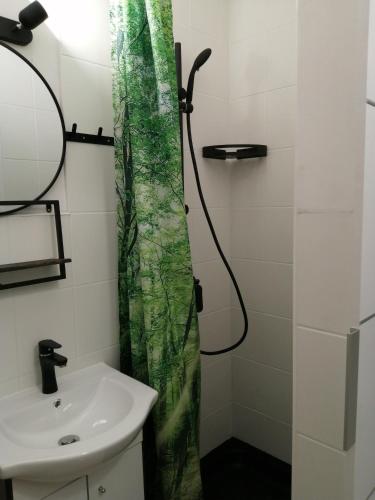a bathroom with a shower curtain and a sink at Przy rynku in Duszniki Zdrój