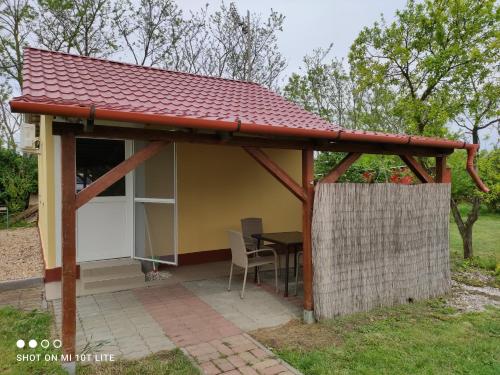 a gazebo with a table and a house at Rákóczi Vendégház in Poroszló
