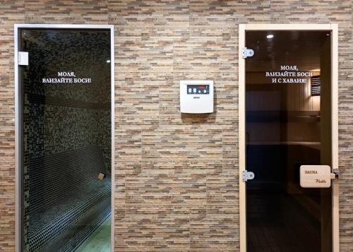 a door to a building with a sign on a brick wall at Hotel Vanilla, Varna - Free parking in Varna City
