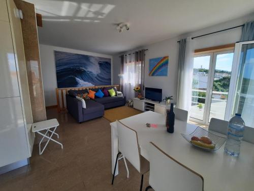 a living room with a table and a couch at Sunflower Sea View with magnificent terrace in Serra da Pescaria, Nazaré - Portugal in Nazaré