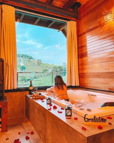 a woman sitting in a tub in a room with a window at Sitio do Galdino in Armazém
