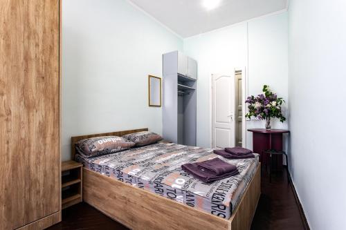a bedroom with a bed with a wooden headboard at Mister Hostel in Lviv