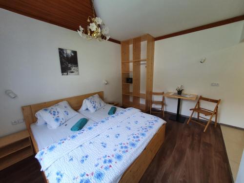 a bedroom with a large bed and a table at Pension INGE in Hinterstoder