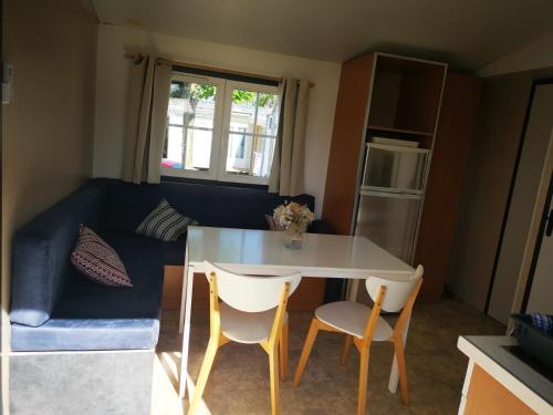 salon ze stołem, krzesłami i kanapą w obiekcie Cocoon mobil home w mieście Saint-Aygulf