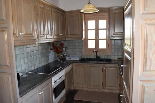 パノロモス・マイコノスにあるVilla Iriniのキッチン(木製キャビネット、シンク、窓付)