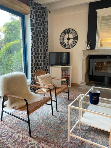 a living room with two chairs and a fireplace at La Gervaiserie - 300m de la plage in Réville