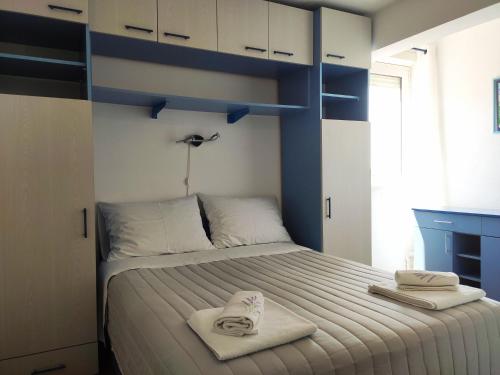 a bedroom with a bed with two towels on it at Apartman Marina II in Rogoznica