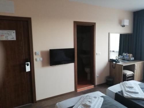 a hotel room with a bed and a television on the wall at Hotel Vanilla, Varna - Free parking in Varna City