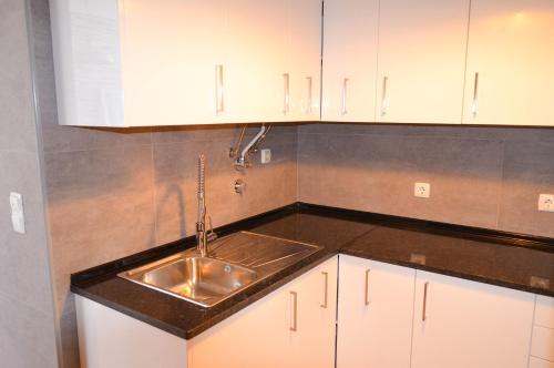 a kitchen with a sink and white cabinets at Casa Vitorino in Sagres