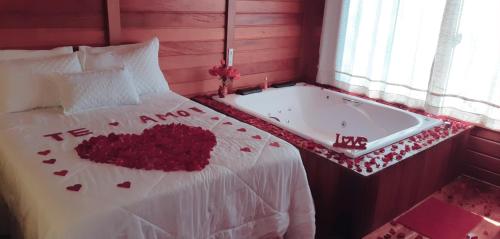 Una cama con una bañera con corazones. en Recanto Della Mata en Venda Nova do Imigrante
