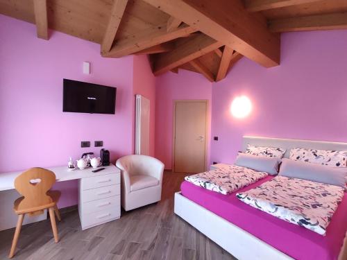 a bedroom with purple walls and a bed and a desk at B&B Il Germoglio in Castione Andevenno