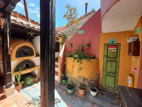 a building with a door and potted plants in front of it at Hotel Boutique La Cueva de la Luna, El Arte se hace Descanso in Duitama