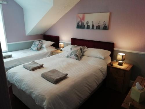 a bedroom with two beds with towels on them at Shirley Heights Hotel in Blackpool