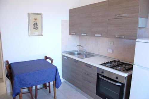 a kitchen with a table and a sink and a stove at Appartamenti Villa Miramare in Capoliveri