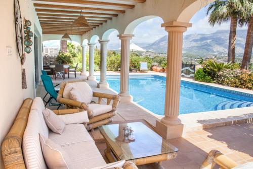 a living room with a swimming pool and a villa at Villa Las Palmeras with private pool and garden in Altea