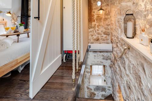 La salle de bains est pourvue d'un mur en pierre et d'un lavabo. dans l'établissement Luxury LeNi Guest House, à Murter