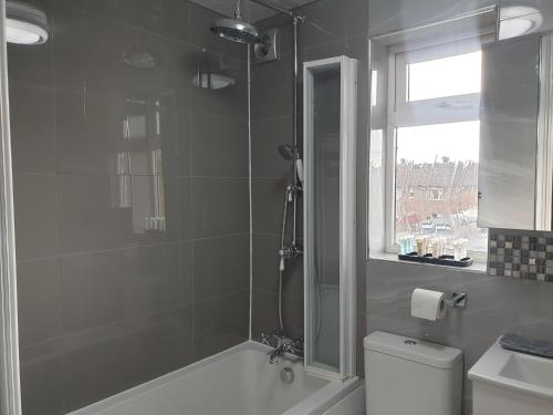 ein Bad mit einer Dusche, einem WC und einem Waschbecken in der Unterkunft JDB Dartford 2-Bedroom House in Dartford