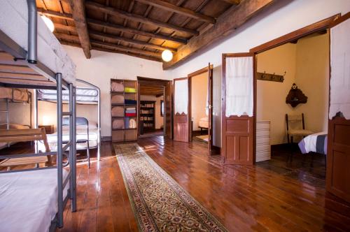 Habitación con literas y suelo de madera. en Albergue Rectoral de Romean en Lugo
