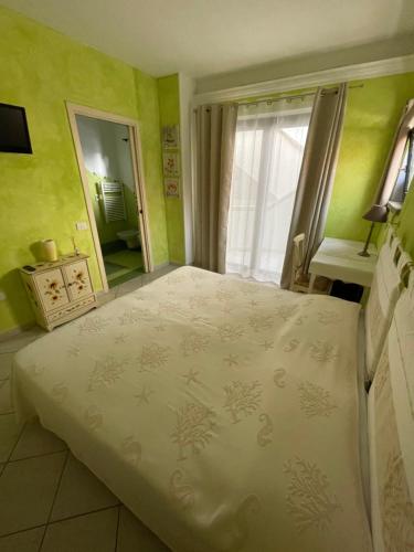 a bedroom with a large white bed with a window at B&B Le Farfalle in Palau