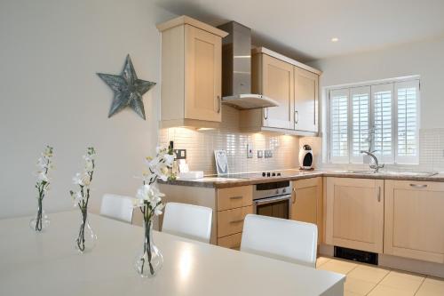 a kitchen with a white table and white chairs at LUXURY BEACHFRONT OUTSTANDING 2 bedroom APARTMENT in Eastbourne
